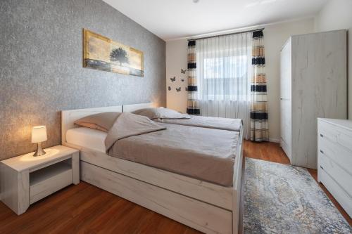 a bedroom with a large white bed and a night stand at Ferienwohnung Sunny in Beckdorf