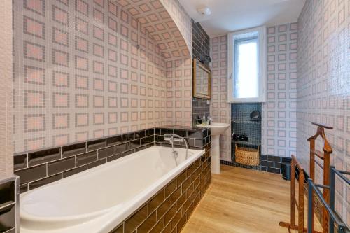 a large bathroom with a tub and a sink at Villa Lin et Maree face océan in Le Croisic
