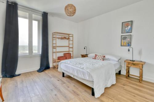 a bedroom with a bed and a large window at Villa Lin et Maree face océan in Le Croisic