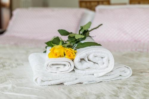 a pile of towels and flowers on a bed at Attico Panoramico in Brunate