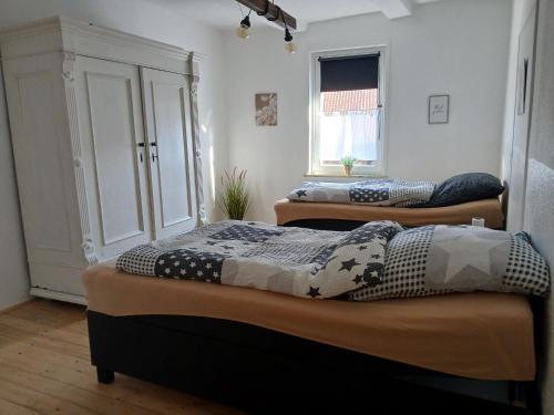 two beds sitting in a room with a window at Ferienwohnung 1 Bartölke in Bockenem