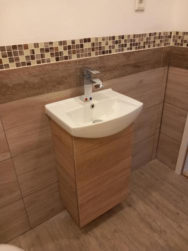 a bathroom with a white sink and wooden floors at Ferienwohnung 1 Bartölke in Bockenem