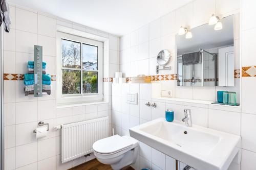 a white bathroom with a sink and a toilet at Haus Lindenfürst in Olsberg