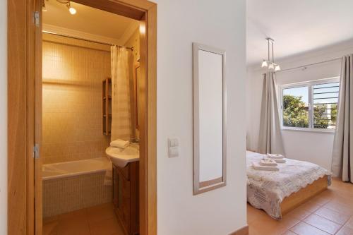 a bathroom with a bed and a sink and a mirror at Quinta Gomeira 69 in Cabanas de Tavira