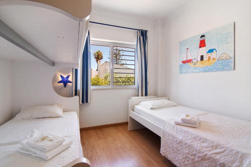 a bedroom with two beds and a window at Quinta Gomeira 69 in Cabanas de Tavira