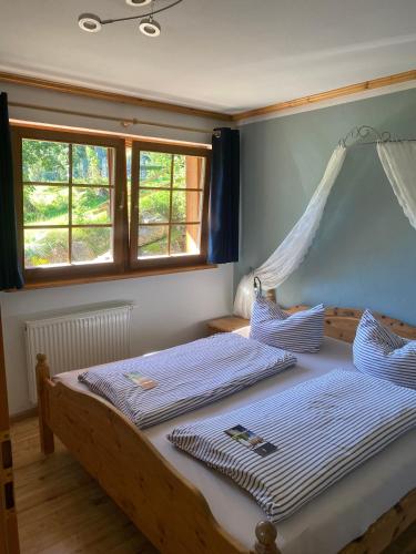 a bedroom with two beds and two windows at Urbanshof Herr Tobias Fehrenbach in Hinterzarten