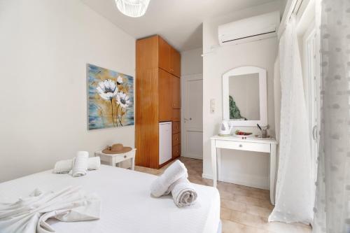 a white bedroom with two beds and a mirror at M1 room in Nikiana