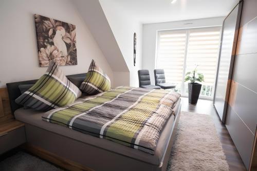a bedroom with a bed with a green blanket and pillows at Gästehaus Lean in Potsdam