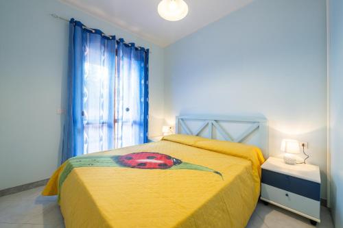 a bedroom with a yellow bed with a bird on it at Residenza del Sole 1 in Villasimius