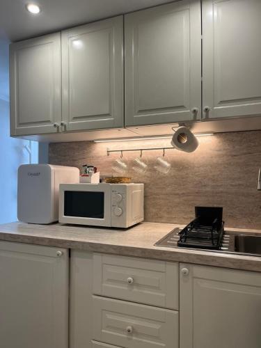 a kitchen with white cabinets and a microwave on a counter at the manchester signature studio A in Manchester