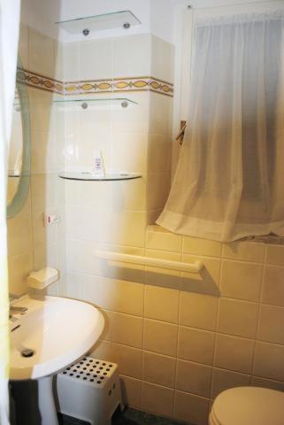 a bathroom with a sink and a toilet and a shower at Appartamento Seccheto Mare in Seccheto