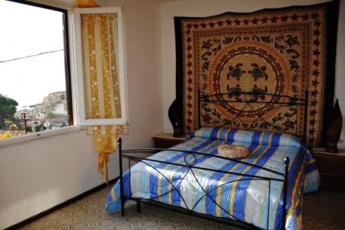 a bedroom with a bed next to a window at Appartamento Seccheto Mare in Seccheto