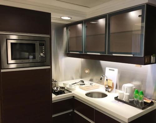 a kitchen with a sink and a microwave at Harbour Plaza 8 Degrees in Hong Kong