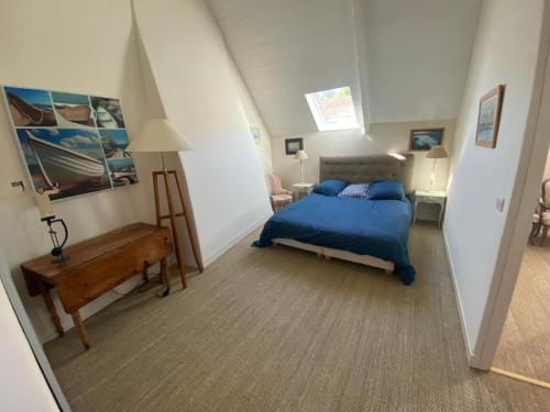 a bedroom with a bed and a desk in a room at Villa Kergariou in Clohars-Carnoët