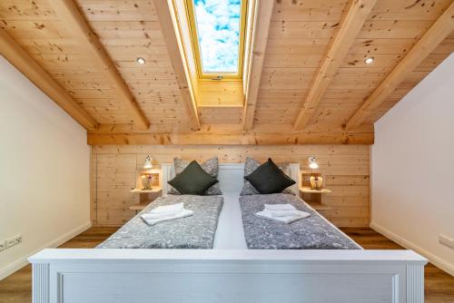 a bed in a room with a wooden ceiling at Wohnung Brauneck in Gaißach