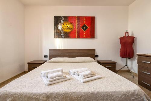 a bedroom with a bed with two towels on it at Casa Vacanze vicino ad alghero in Olmedo