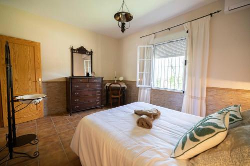 a bedroom with a bed with a teddy bear on it at Villa mis Raices in Castilblanco de los Arroyos