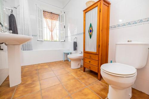 a bathroom with a toilet and a sink at Villa mis Raices in Castilblanco de los Arroyos