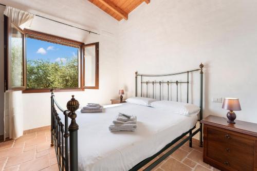 a bedroom with a large bed and a window at Villa Is Sorrisi in Gonnesa