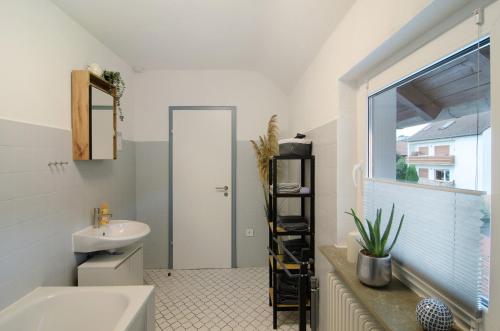 a bathroom with a sink and a toilet and a window at Ferienwohnung Storchenblick in Grebendorf
