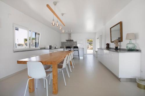 a kitchen and dining room with a wooden table and chairs at Peace House Lourinhã in Lourinhã