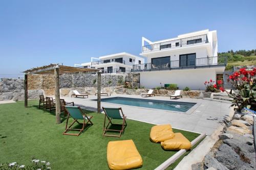 a villa with a swimming pool and a house at Peace House Lourinhã in Lourinhã