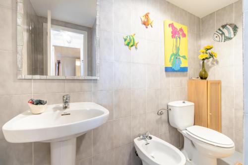 a bathroom with a sink and a toilet and a mirror at Taiko in Port de Pollensa
