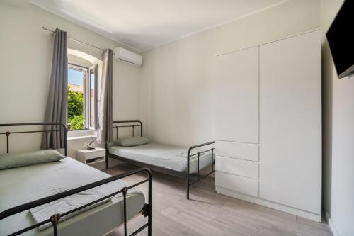 a bedroom with two beds and a window at Casa Sparto in Meganisi