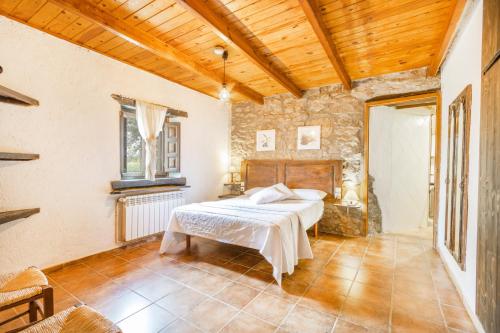 a bedroom with a bed and a wooden ceiling at El Porxet in Navés