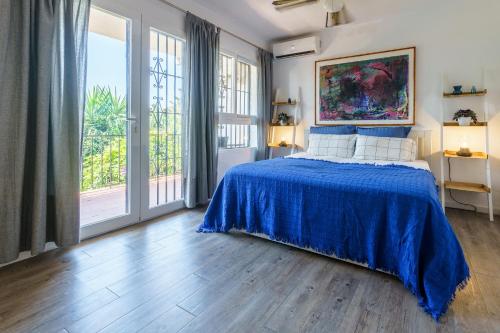 a bedroom with a bed with a blue bedspread at La Ponderosa 5 in Mijas Costa