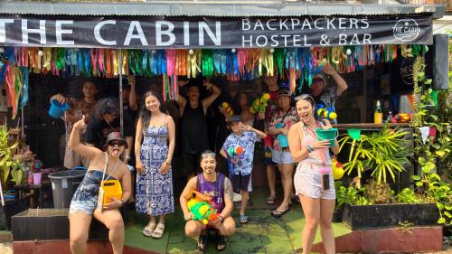 a group of people standing in front of a bar at The Cabin Backpackers Hostel & Bar in Chiang Mai