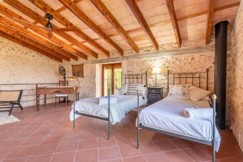 a bedroom with two beds in a room with a piano at Sa Teulera de Sencelles in Sencelles
