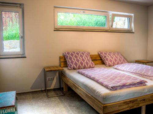 a bedroom with a bed and two windows at Alpenblick 1 in Lindau-Bodolz