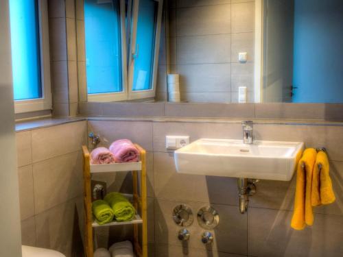 a bathroom with a sink and a mirror and towels at Alpenblick 1 in Lindau-Bodolz