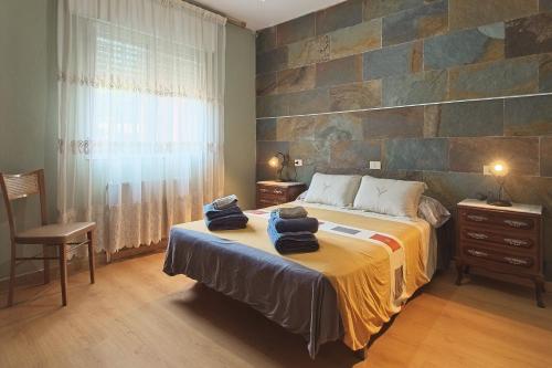 a bedroom with a bed and a stone wall at Pisos Leopoldo - Casaio in Casayo