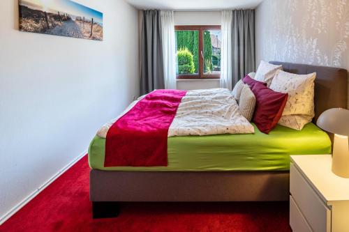 a bedroom with a bed with colorful blankets and pillows at Ferienwohnung Efzeglück mit Pool in Homberg