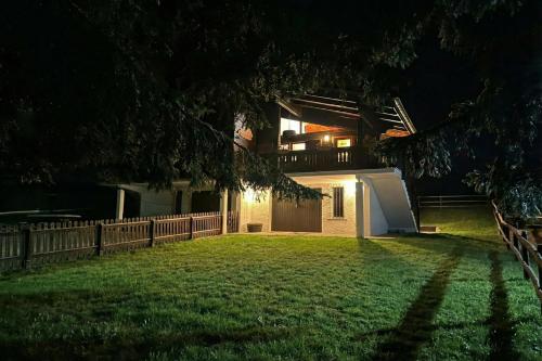 a house with a fence and a yard at night at Chalet Soleada with Fireplace and Terrace for 5 - Happy Rentals in Pian San Giacomo