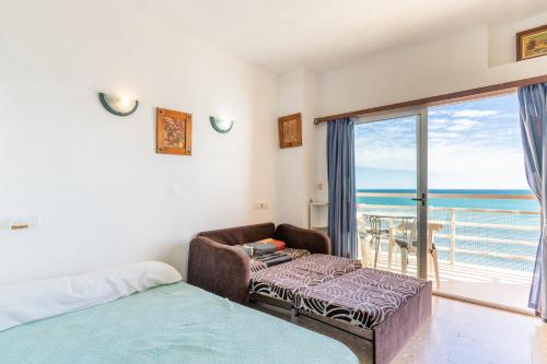 a bedroom with a bed and a balcony with the ocean at Calpe primera linea con piscina in Casas de Torrat