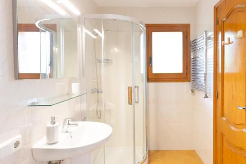 a white bathroom with a sink and a shower at Ca la Irene I in Begur
