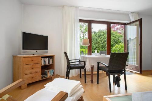a living room with a tv and chairs and a table at Lieblingsnest in Grübels