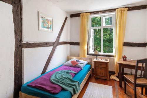 a bedroom with a bed and a desk and a window at Altes Polchower Pfarrhaus in Alt Polchow