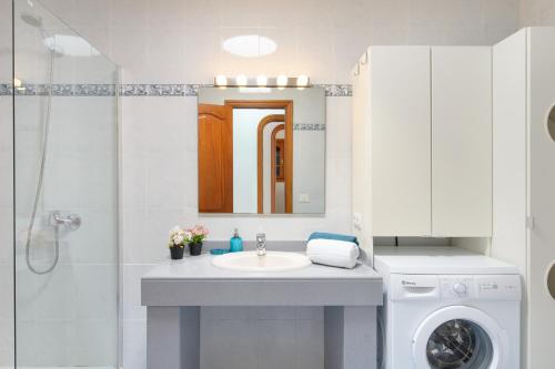 a bathroom with a sink and a washing machine at Salitre in Playa Honda