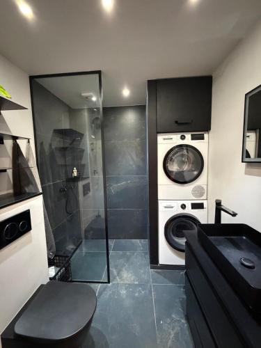 a bathroom with a washing machine and a washer at Design Apartment in Vesterbro with Large Balcony in Copenhagen
