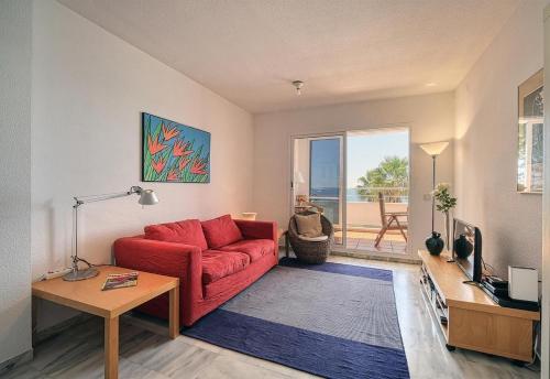 a living room with a red couch and a view of the ocean at Apartment Boulevard 105 in Estepona