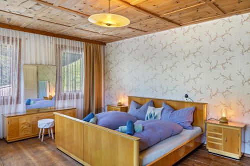 a bedroom with a large bed with blue pillows at A Nett’s Nest - Haus in Hainzenberg