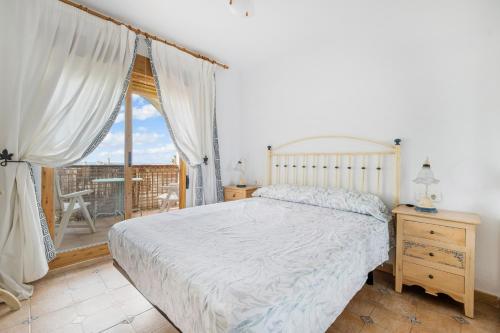 a bedroom with a large bed and a balcony at Casa Varadero in Santa Pola
