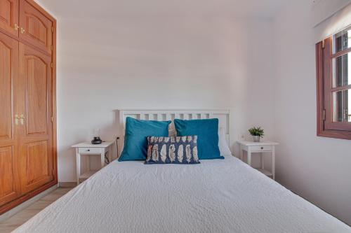 a bedroom with a large bed with blue pillows at Casa Ann in Arrecife