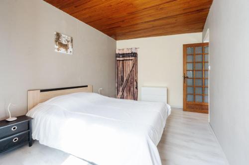 a bedroom with a white bed and a wooden ceiling at Gîte Zen Attitude in Saint-Martin-sur-le-Chambre