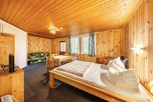 a bedroom with a bed in a wooden room at Bungalow 13 - Finnhütte in Niesky