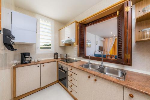 a small kitchen with a sink and a window at Casa Laura in Cala Ratjada